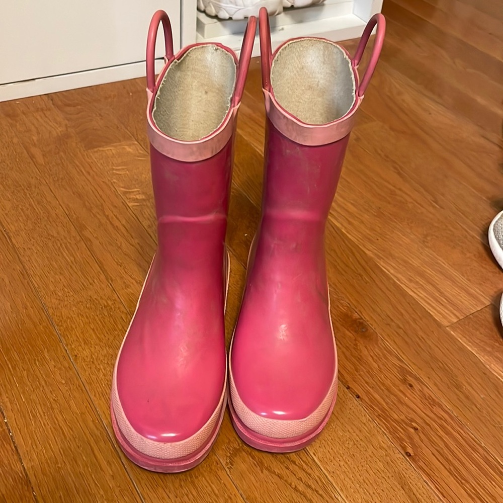 Pink rubber shin high boots with little half circles on top water prof